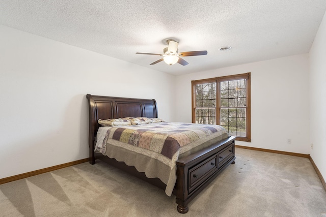 carpeted bedroom with a textured ceiling and ceiling fan