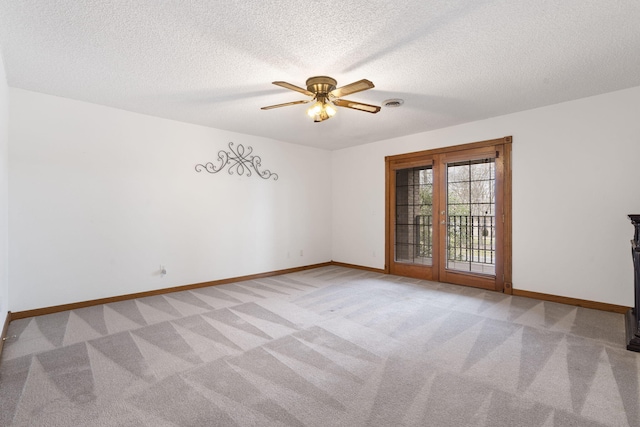 empty room with ceiling fan, light colored carpet, and a textured ceiling