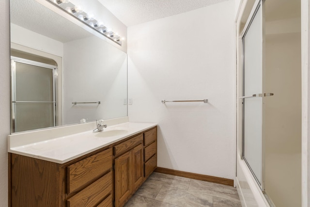 bathroom with vanity, a textured ceiling, and shower / bath combination with glass door