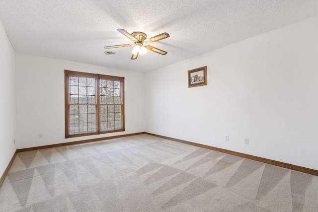 carpeted empty room featuring ceiling fan and a textured ceiling