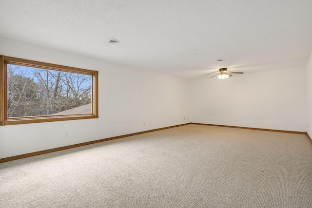 carpeted empty room with ceiling fan and a textured ceiling