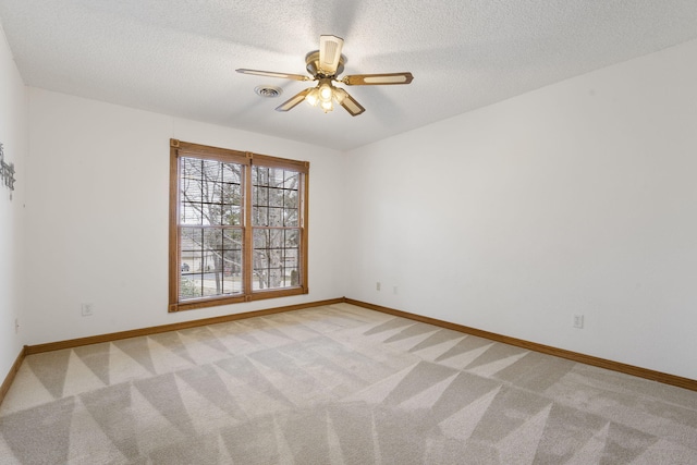 carpeted spare room featuring a textured ceiling and ceiling fan