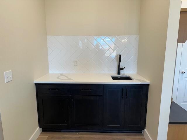 interior space with wood-type flooring, sink, and backsplash