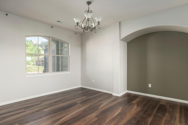 unfurnished room featuring dark hardwood / wood-style floors and a notable chandelier