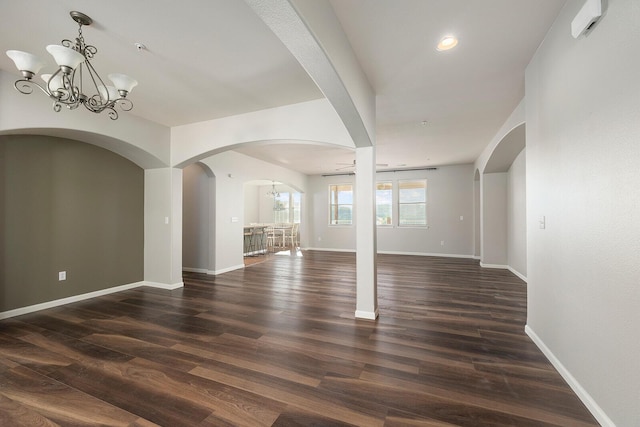 interior space with ceiling fan with notable chandelier and dark hardwood / wood-style floors