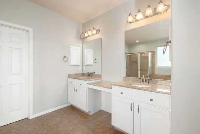 bathroom with tile patterned floors, a shower with door, and vanity