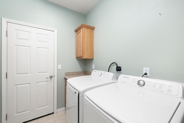 clothes washing area with cabinets, light tile patterned floors, and independent washer and dryer