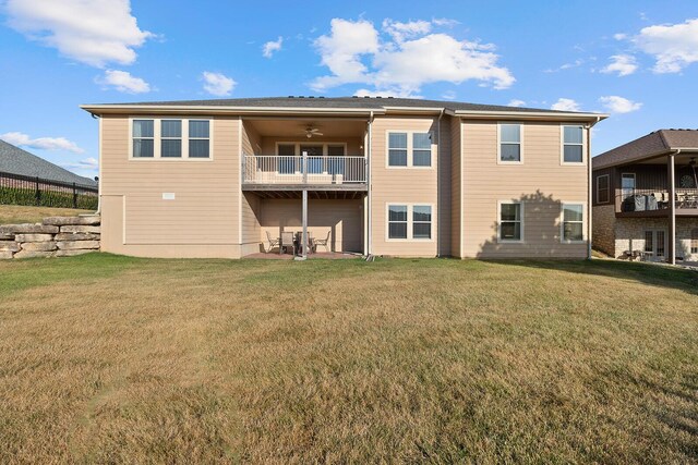 back of property featuring a balcony, a lawn, and ceiling fan