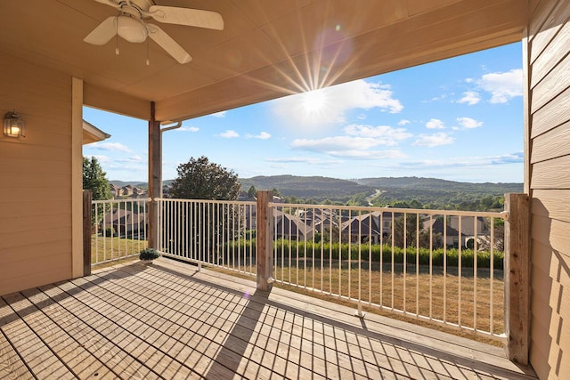 view of patio featuring a mountain view, ceiling fan, and a balcony