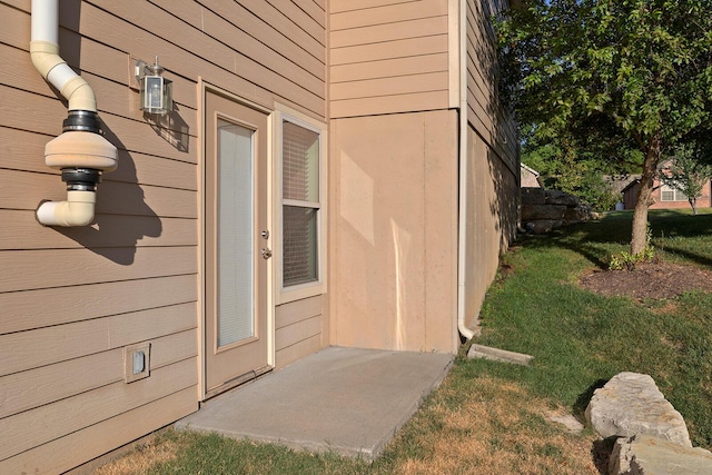 doorway to property featuring a lawn