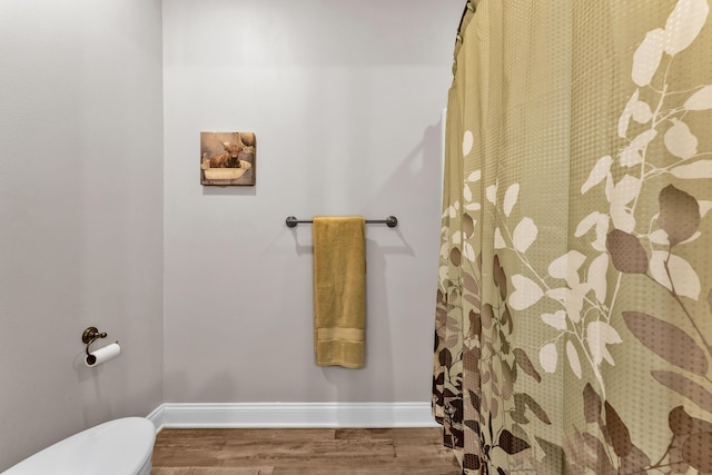 bathroom with hardwood / wood-style flooring and toilet