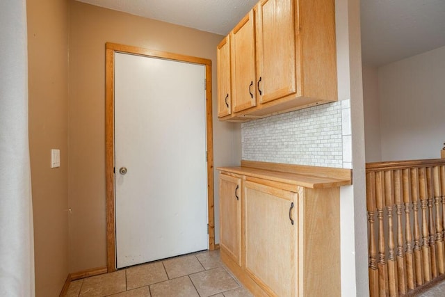 kitchen featuring light tile patterned floors, backsplash, and light brown cabinetry