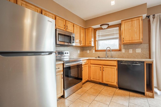 kitchen featuring light tile patterned flooring, appliances with stainless steel finishes, sink, and backsplash