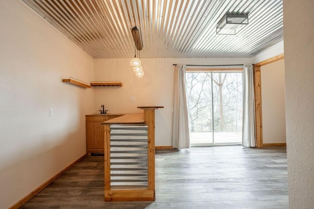 bar with dark wood-type flooring, wood ceiling, and hanging light fixtures