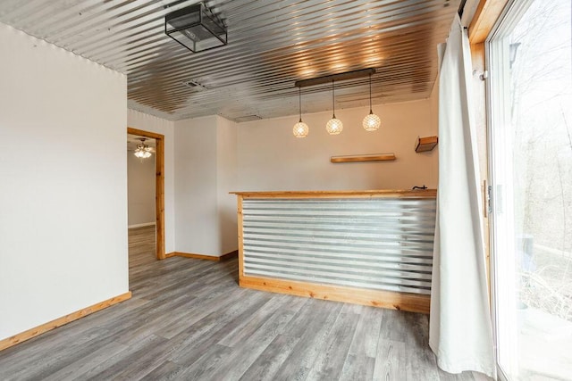 bar with wood-type flooring and decorative light fixtures