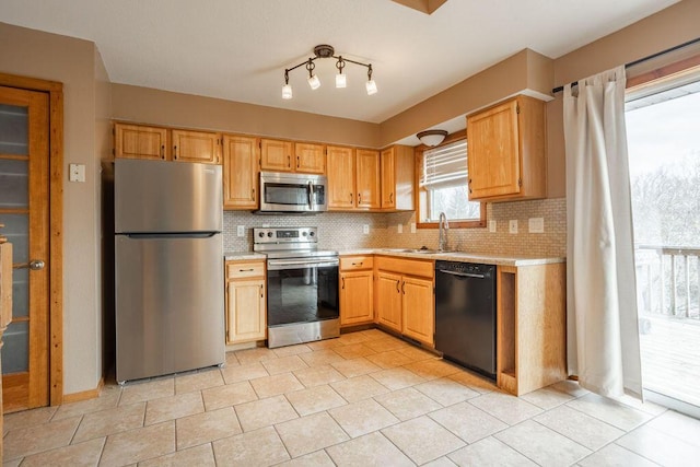 kitchen featuring sink, decorative backsplash, stainless steel appliances, and light tile patterned floors