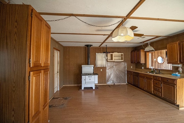 kitchen featuring sink, decorative light fixtures, ceiling fan, and light wood-type flooring