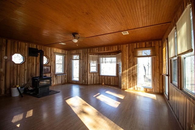 unfurnished living room with ceiling fan, wooden ceiling, hardwood / wood-style floors, and a wood stove