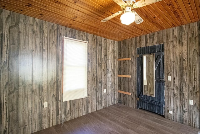 spare room with ceiling fan, wooden walls, dark hardwood / wood-style floors, and wooden ceiling