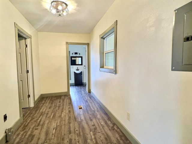 corridor featuring dark wood-type flooring and electric panel