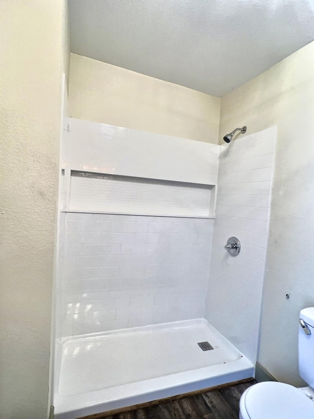 bathroom featuring toilet, hardwood / wood-style floors, and a shower