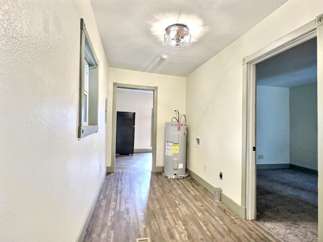 hall with hardwood / wood-style floors and water heater