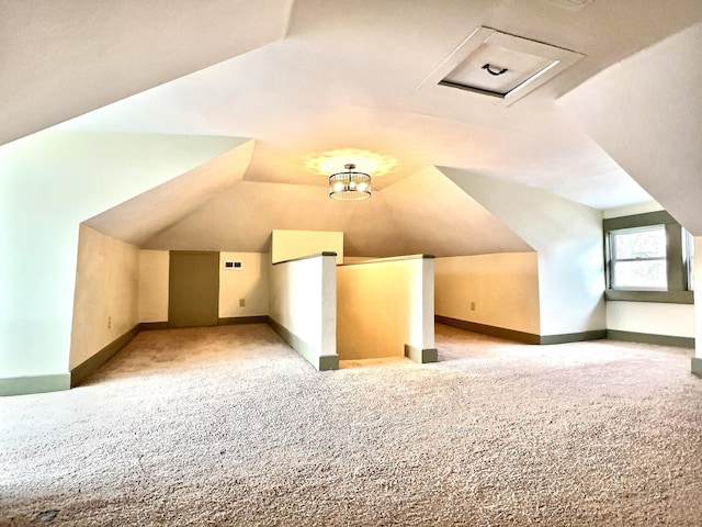 additional living space featuring vaulted ceiling and light carpet