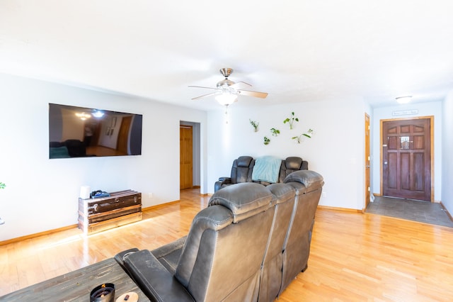 living area featuring ceiling fan, light wood-type flooring, and baseboards