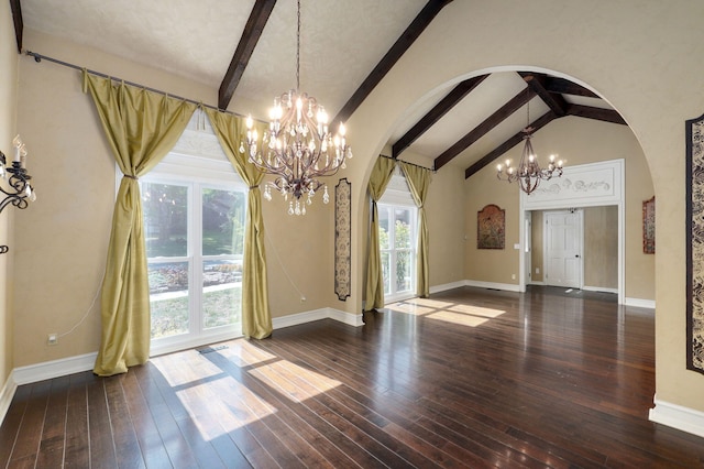 unfurnished dining area featuring an inviting chandelier, beam ceiling, dark wood-type flooring, and a wealth of natural light