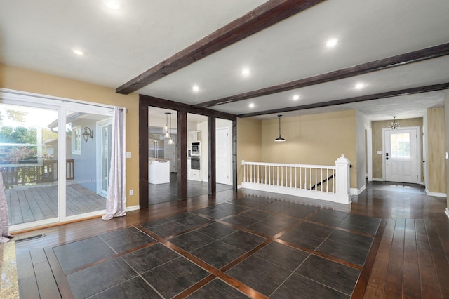 spare room with beamed ceiling, dark hardwood / wood-style floors, and an inviting chandelier