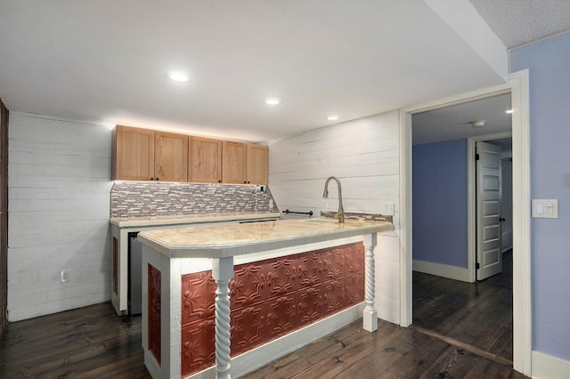 kitchen with dark hardwood / wood-style flooring, light brown cabinetry, and decorative backsplash