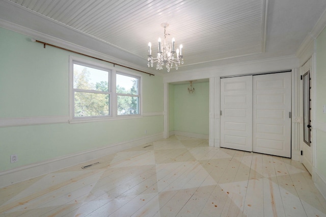 unfurnished bedroom featuring an inviting chandelier, crown molding, and light hardwood / wood-style floors