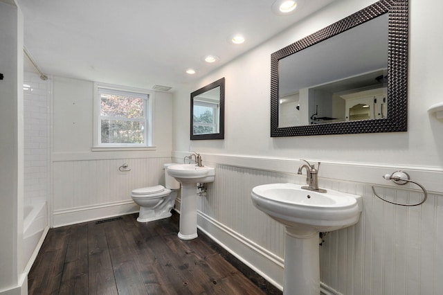 full bathroom with bathing tub / shower combination, sink, hardwood / wood-style floors, and toilet