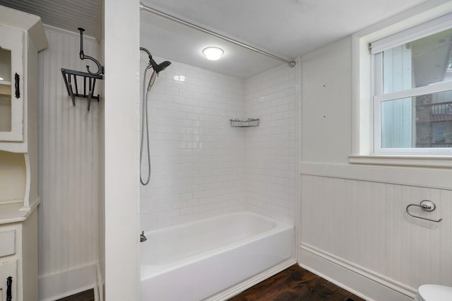 bathroom with tiled shower / bath, toilet, and hardwood / wood-style floors