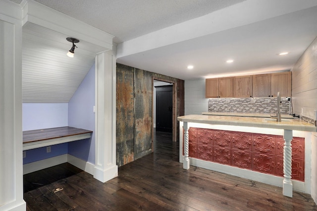 kitchen with lofted ceiling, dark wood-type flooring, and backsplash