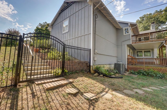 view of side of home with a balcony, a yard, covered porch, and central air condition unit