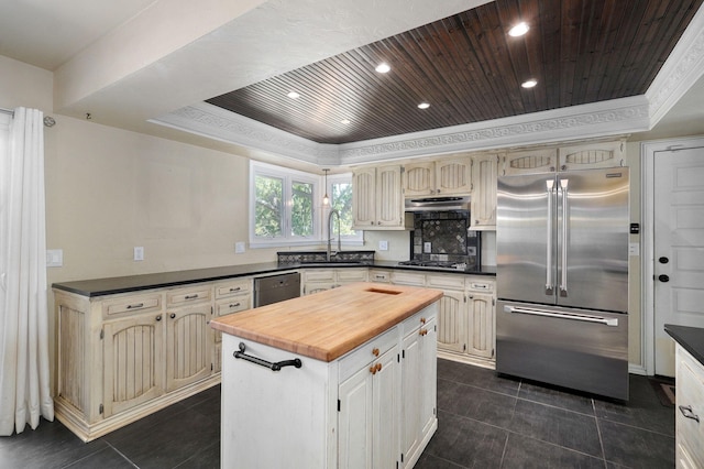 kitchen featuring wood ceiling, a kitchen island, a raised ceiling, and appliances with stainless steel finishes