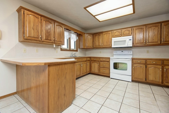 kitchen with sink, light tile patterned floors, white appliances, and kitchen peninsula