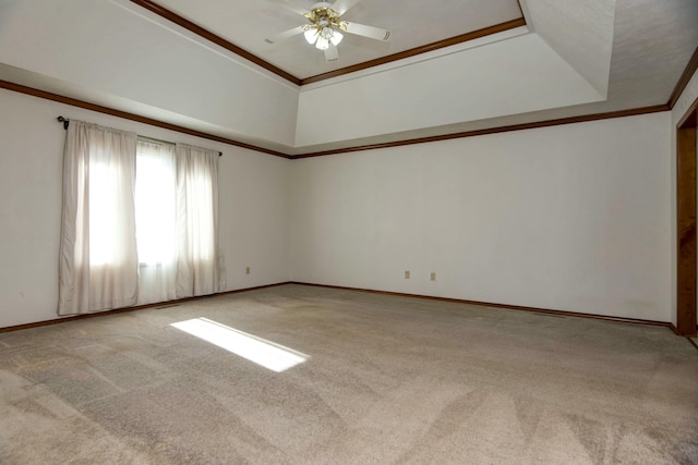 carpeted spare room with a tray ceiling, ornamental molding, ceiling fan, and a high ceiling