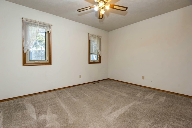 carpeted spare room with ceiling fan