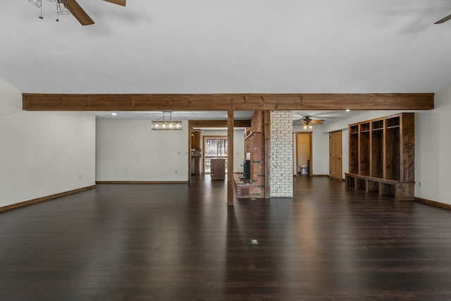 unfurnished room featuring ceiling fan, dark wood-type flooring, and beamed ceiling