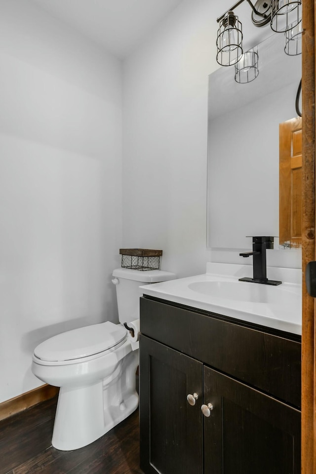 bathroom with vanity, toilet, and hardwood / wood-style floors