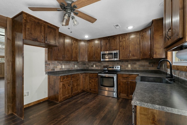 kitchen featuring dark hardwood / wood-style floors, sink, backsplash, stainless steel appliances, and dark brown cabinets