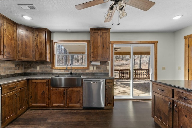 kitchen featuring sink, dark hardwood / wood-style floors, a textured ceiling, decorative backsplash, and stainless steel dishwasher