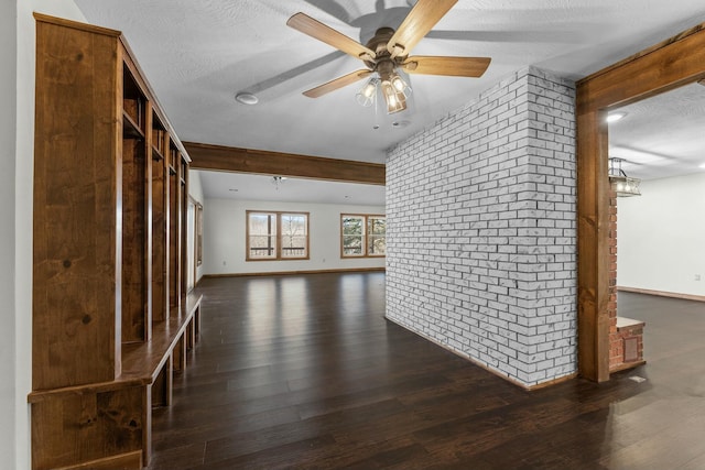 unfurnished room featuring ceiling fan, brick wall, dark hardwood / wood-style floors, and a textured ceiling