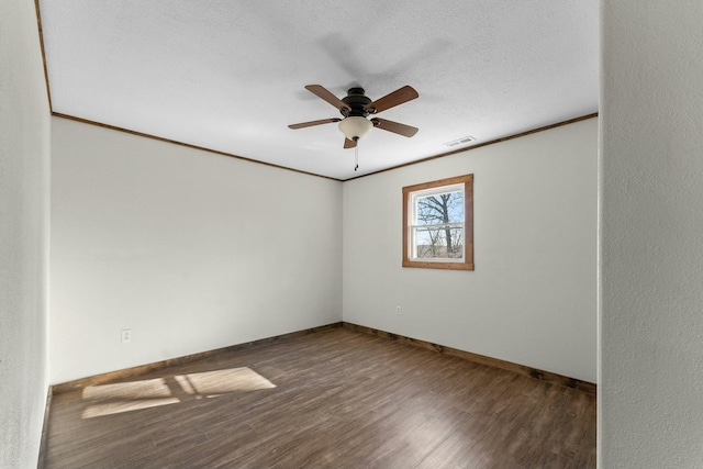 empty room with crown molding, dark wood-type flooring, a textured ceiling, and ceiling fan