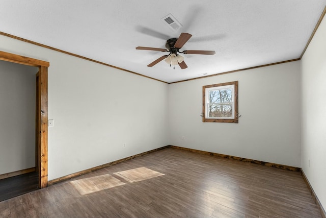 spare room featuring dark hardwood / wood-style flooring, ornamental molding, and ceiling fan