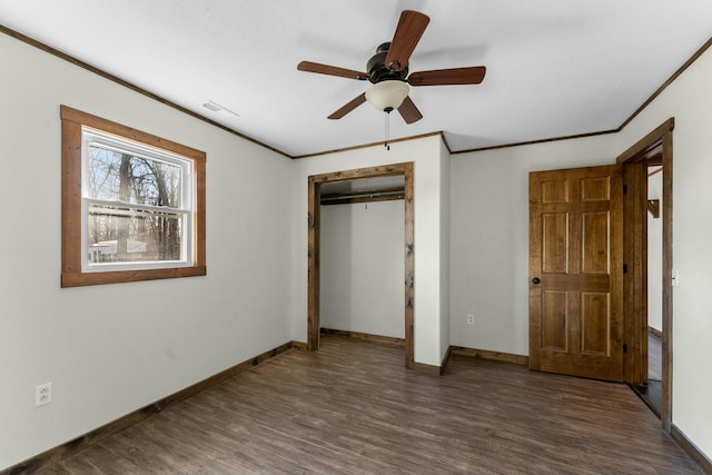 unfurnished bedroom featuring ceiling fan, ornamental molding, dark hardwood / wood-style flooring, and a closet