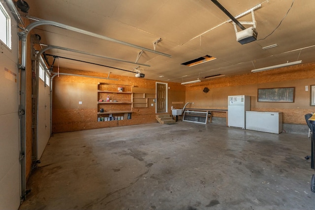 garage featuring a garage door opener and white fridge