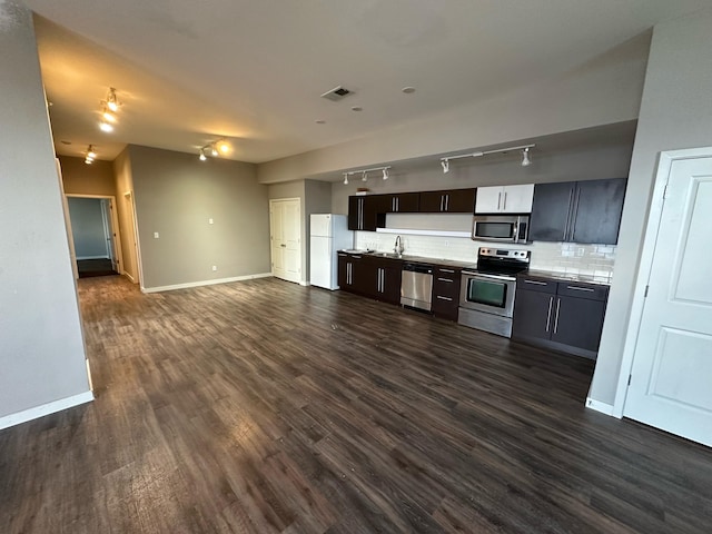 kitchen featuring sink, dark brown cabinets, stainless steel appliances, dark hardwood / wood-style floors, and decorative backsplash